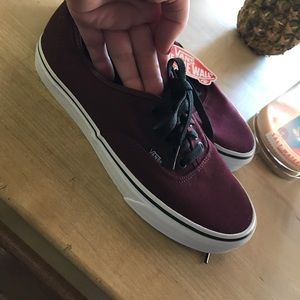 Burgundy vans with tags on them